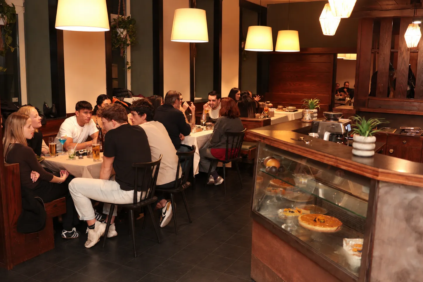 Comensales en el salón de Aguacate en Viena, sentados a las mesas disfrutando platos venezolanos.